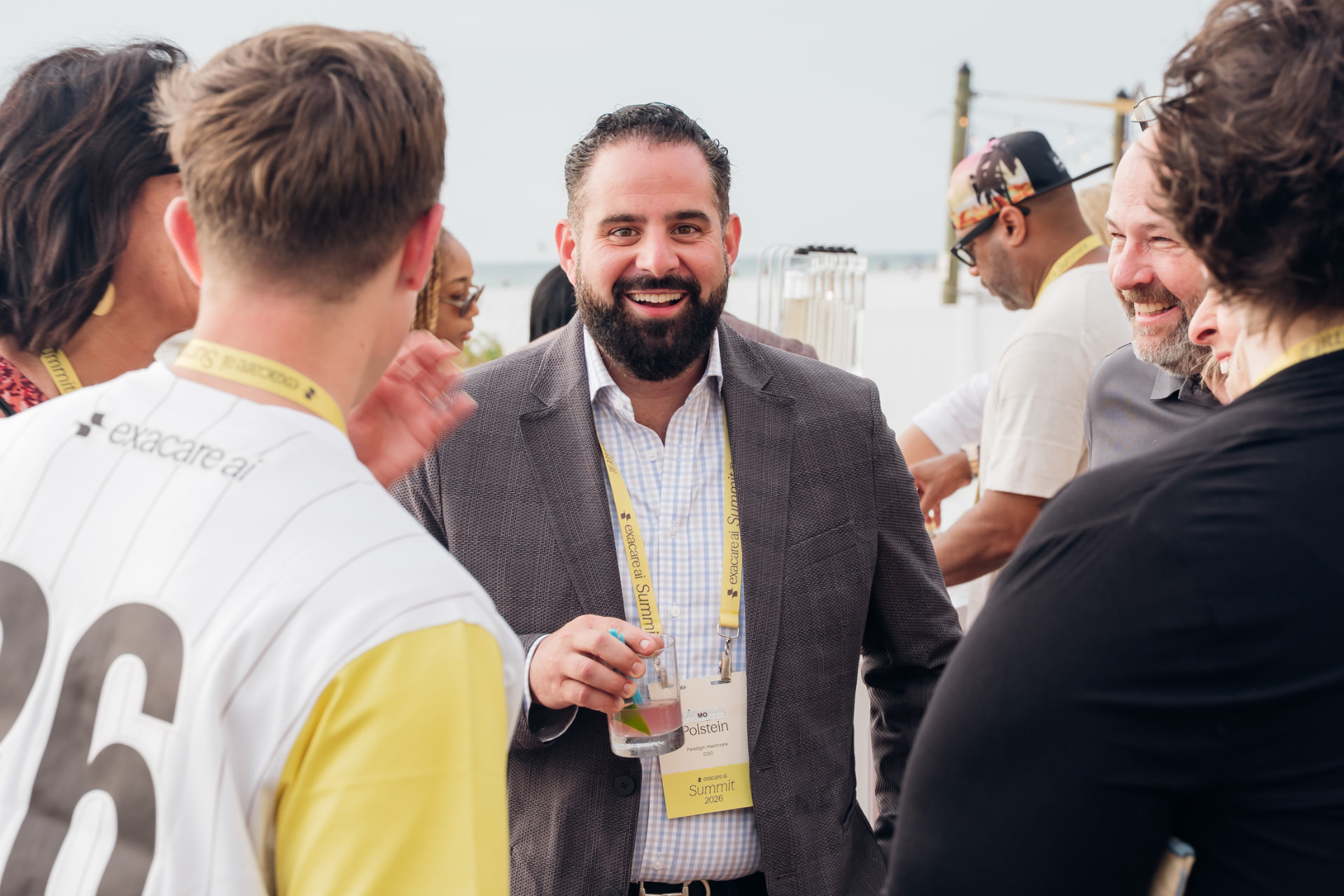 Corporate photography of executives networking with name badges at a waterfront corporate summit